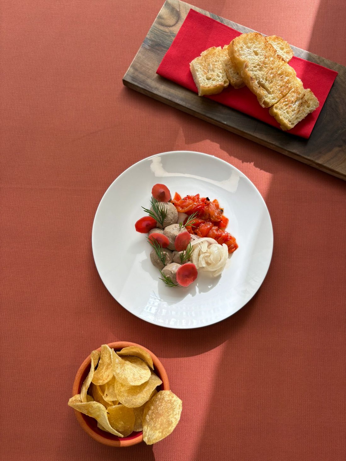 Piščančji pâté s popečenim kruhom in čipsom na večerni mizi