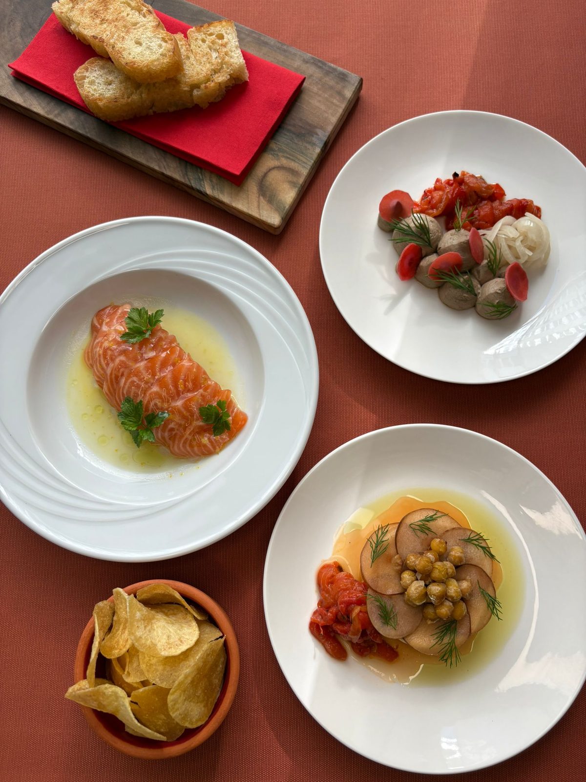 Pogrnjena miza s predjedmi: carpaccio lososa, pâté in humus